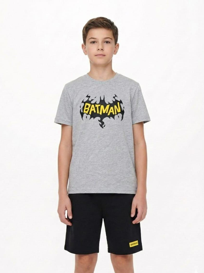 Child wearing a gray t-shirt with a Batman logo on a white background
