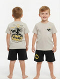 Two children wearing matching t-shirts and shorts with a Batman logo on a white background