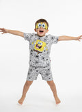 Child wearing SpongeBob SquarePants pajamas with arms outstretched on a white background