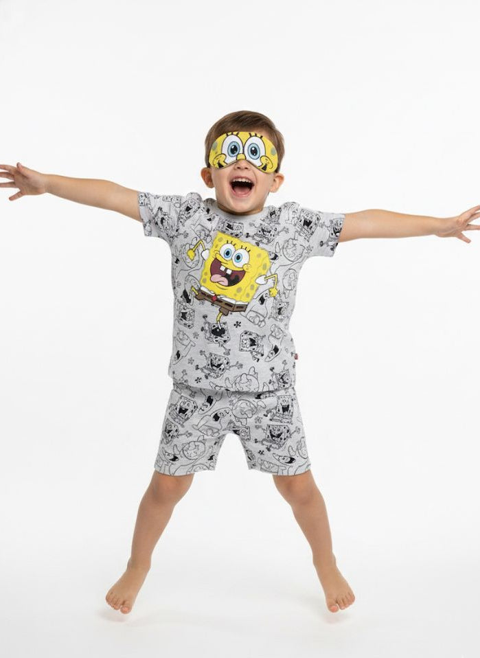 Child wearing SpongeBob SquarePants pajamas with arms outstretched on a white background